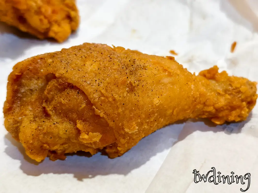 這支謝謝炸雞 crispy drumstick 擁有完美的 golden skin 金黃外皮，表面灑上 pepper 點綴，咬下後 juicy interior 多汁肉質與 flaky texture 脆皮結合，是 american style 最道地的極致美味。