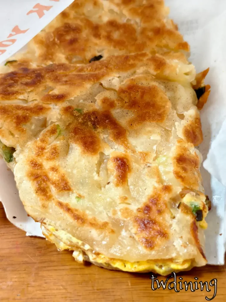 金黃 Green Onion Pancake 蔥抓餅在 阿婆早餐 現煎，Scallion Aroma 蔥香四溢搭配 Layered Crust 層次餅皮呈現極致 Crunchy 酥脆感。