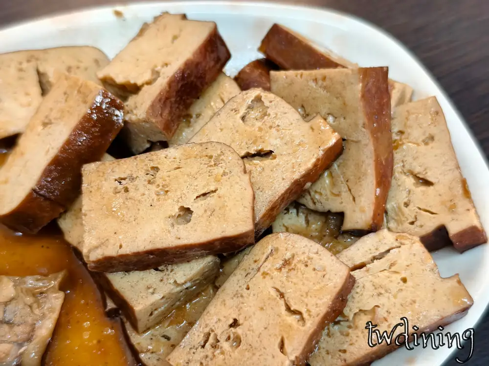 滷到孔洞吸飽滷汁的 dried black tofu，口感 spongy and dense 且散發 soy fragrance，這份 北海魷魚焿 的豆乾是 taichung beiping road 最入味的古早味滷味小菜。