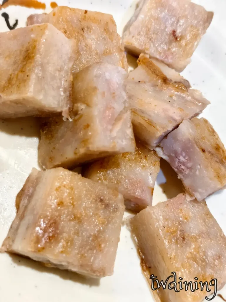 golden-brown 芋頭糕 with crispy-edges. these savory radish cake pieces have a soft-tender texture. 表面煎到金黃焦香，每一口都充滿 authentic aroma, 展現驢磨坊傳統小吃的 visual essence.