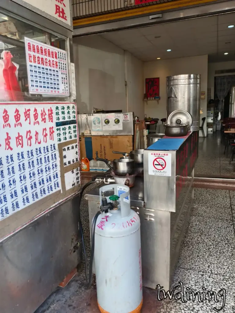 從台中市北區 taichung north district 漢口路 hankou road 台南小吃 tainan snacks 的門口廚房 kitchen 視角可以看到開放式烹飪區 open cooking area 與牆面上的大字菜單 menu。