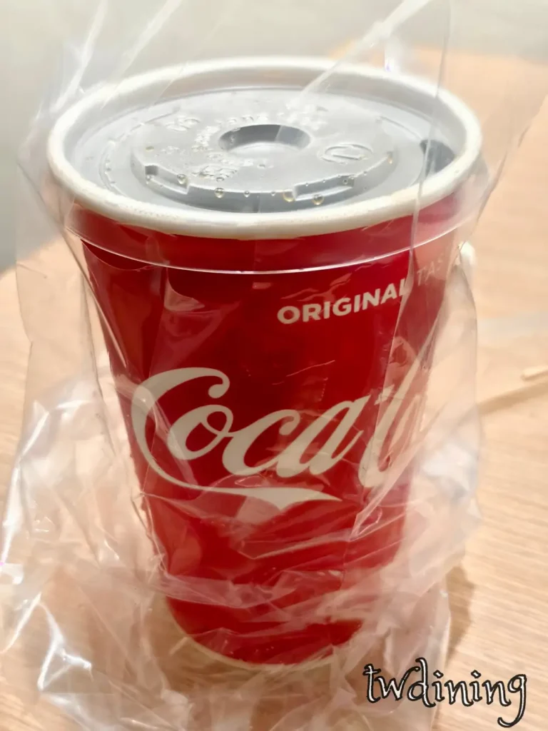 這杯謝謝炸雞 iced coca cola 滿滿 ice cubes 超沁涼，red cup 紙杯滴著 condensation 水珠放在 plastic bag 裡，搭配 fried chicken 根本是完美的 soft drink 靈魂組合。