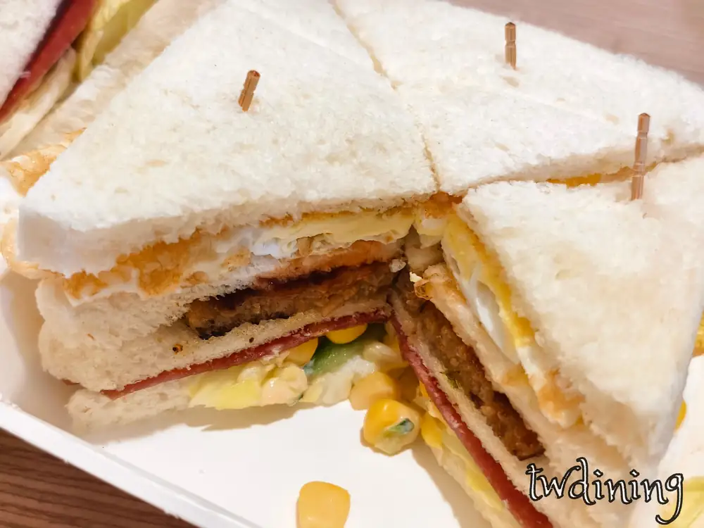 滿意早點 Man Yi Brunch 里肌豬排總匯三明治 pork chop club sandwich，層次分明 rich layers 與嫩蛋 tender egg、火腿 ham、玉米粒 corn，展現豐富斷面視覺 high-volume breakfast.
