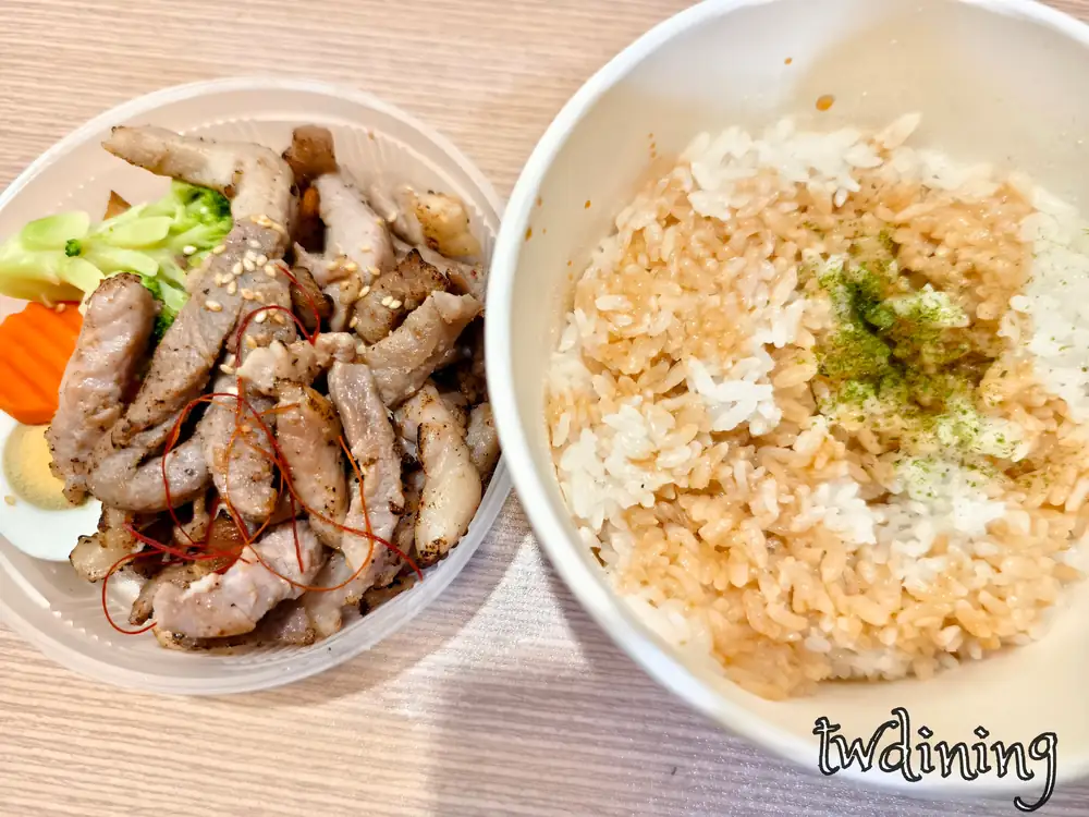 九本家蔥鹽豬柳丼包含炙燒豬肉條、青花菜、胡蘿蔔與半顆滷蛋，配菜與白飯分開盛裝，白飯灑有海苔粉與特製醬汁，展現日式便當擺盤與客觀配料組成。