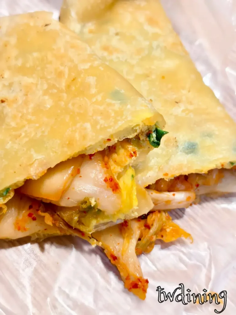 Tender egg pancake with spicy-kimchi filling. Skin is slightly crispy-edges. 酥軟蛋餅包入酸辣 crunchy-kimchi，每一口都 steaming-hot 且富有層次，展現驢磨坊創意小吃的 visual essence。