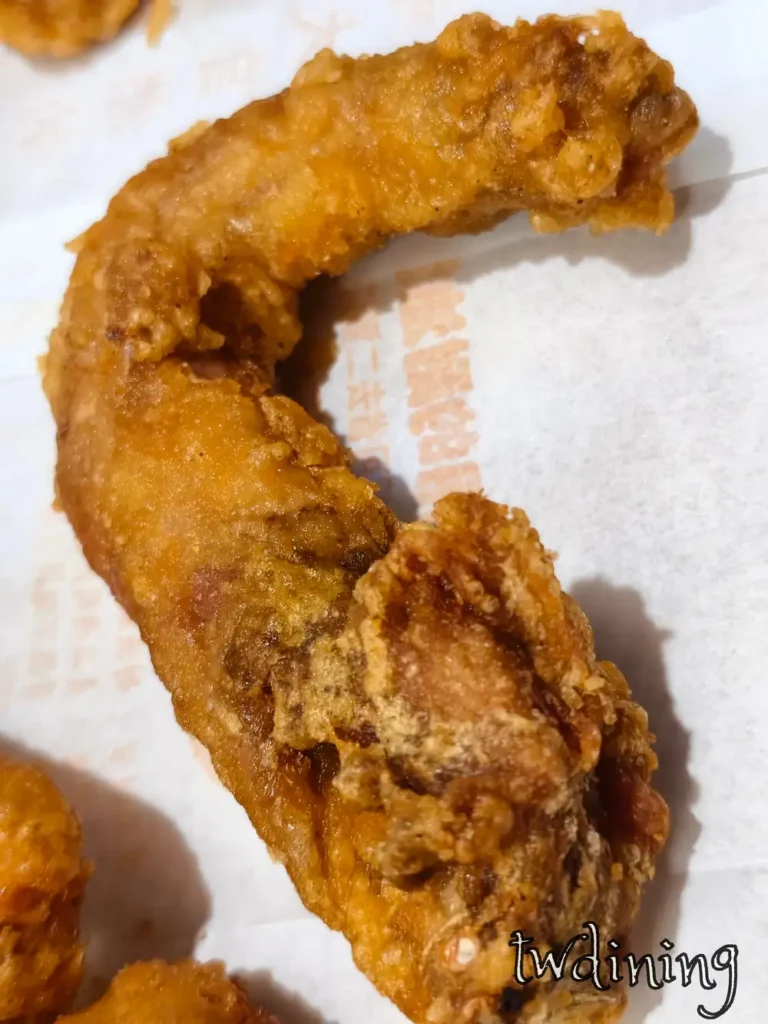 正騰和炸雞脖子特寫，金黃酥脆的炸衣包裹著嫩肉，展現 flaky texture 的視覺精髓，是台中北平路三段受歡迎的銅板價炸物小吃，適合當作宵夜點心。