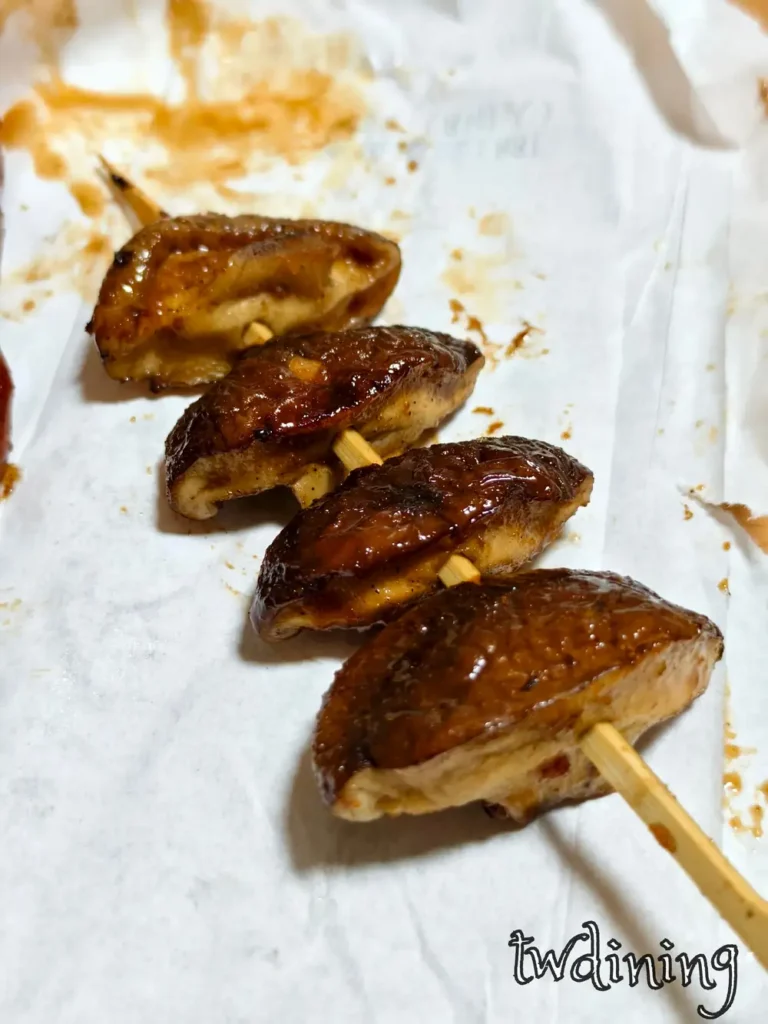 這串 grilled shiitake mushrooms 烤得極其 juicy，表面裹上一層 glossy savory sauce，每一口都能吃到 mushroom juice 與炭烤香氣交織，是 bbq skewer 中必點的 healthy choice。