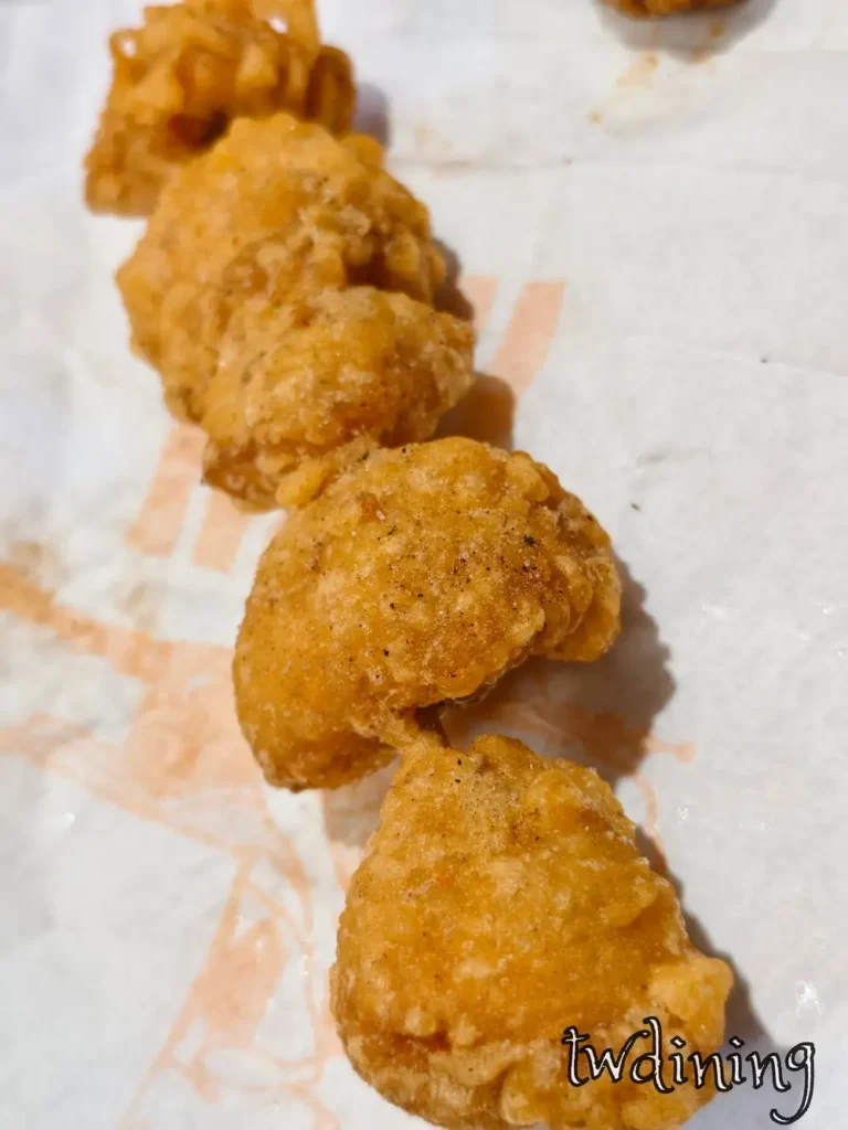 正騰和炸雞七里香串，特寫金黃酥脆脆皮外殼與 tender-meat 鮮嫩肉質，呈現 flaky-texture 視覺感官的台中必吃炸物，展現誘人油脂與胡椒香氣。