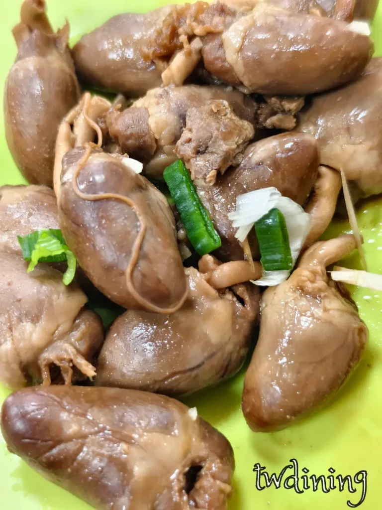 郭家水餃台式滷雞心小菜。飽滿有光澤雞心搭配鮮綠蔥花與細薑絲。綠盤盛裝滷製入味鹹香雞心。特寫呈現豐富油光感與彈性食材細節。